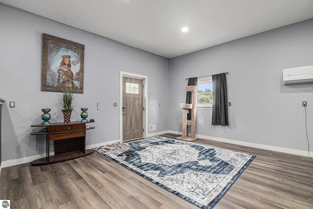 foyer entrance with a wall mounted AC and wood-type flooring