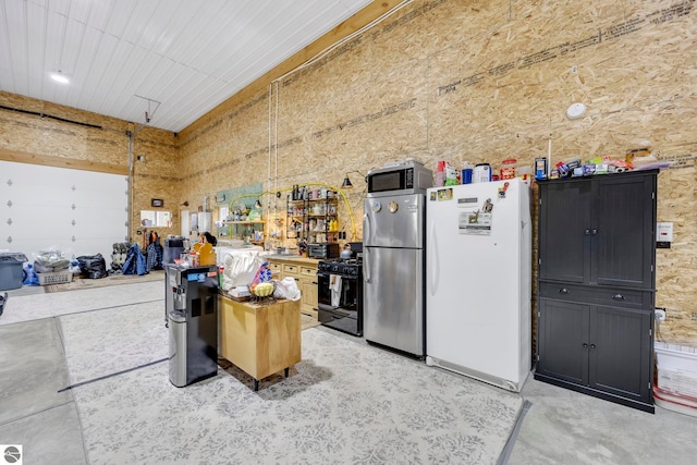 garage featuring stainless steel fridge and white refrigerator