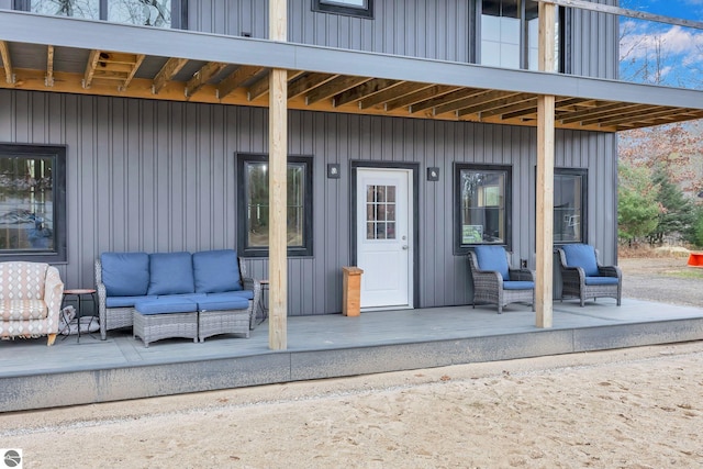 view of exterior entry featuring an outdoor living space and a patio