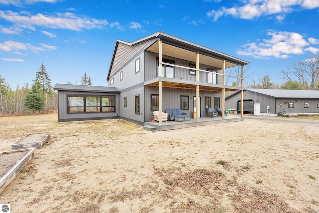 rear view of property with a balcony and an outdoor hangout area