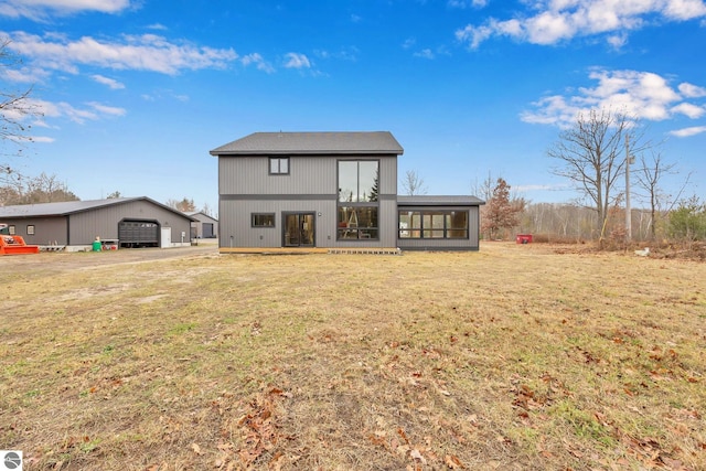 back of property with a lawn and a garage