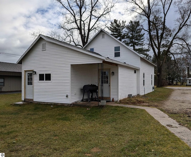 rear view of house featuring a yard