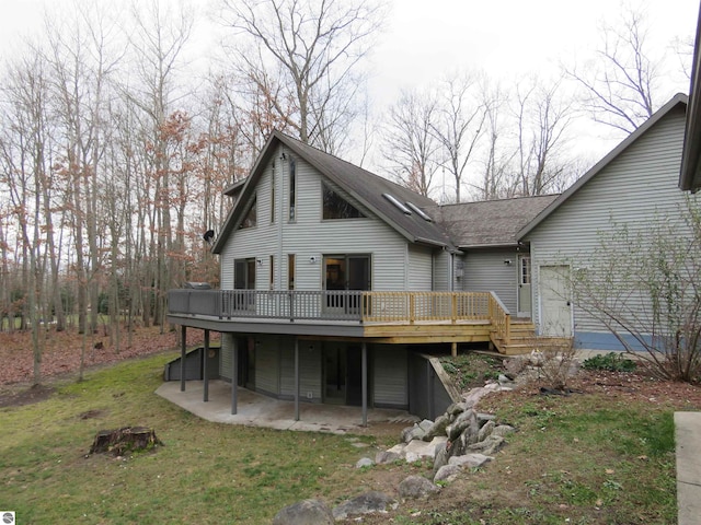 back of property with a lawn and a deck