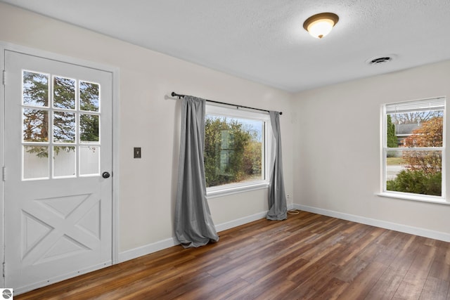 interior space featuring dark hardwood / wood-style flooring and a textured ceiling