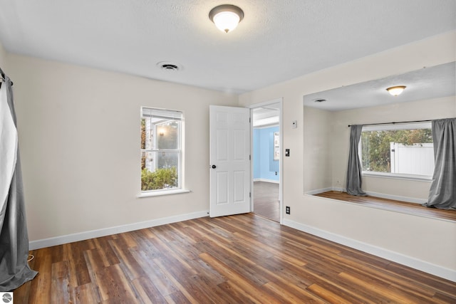 unfurnished bedroom featuring dark hardwood / wood-style flooring and a textured ceiling