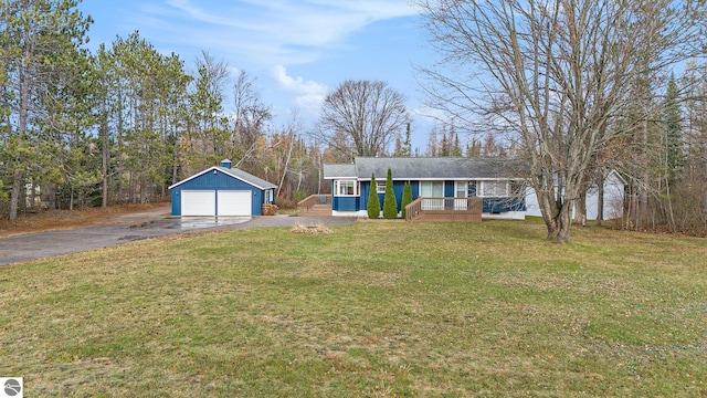 single story home featuring an outbuilding, a front lawn, a porch, and a garage