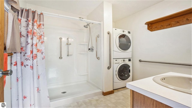 bathroom featuring a shower with curtain, vanity, and stacked washer and clothes dryer