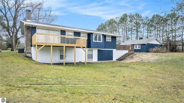 rear view of property with central AC unit, a deck, and a yard