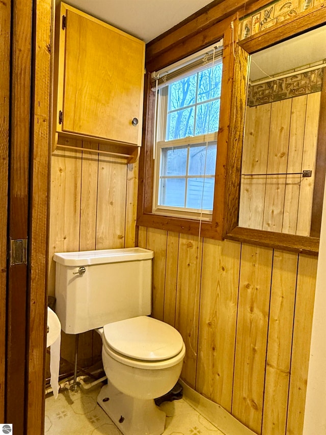 bathroom featuring toilet and wooden walls