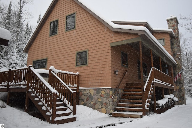 view of snow covered rear of property