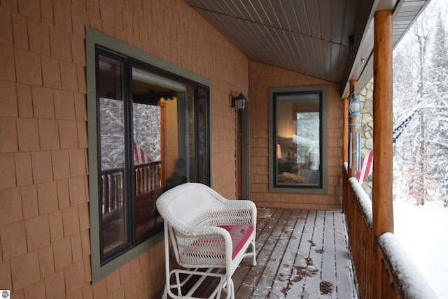 snow covered back of property with a porch