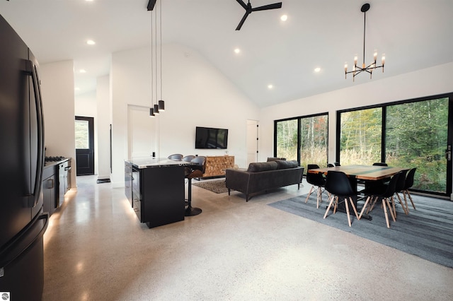 living room with ceiling fan with notable chandelier and high vaulted ceiling