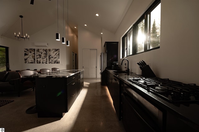 kitchen with a breakfast bar, black appliances, sink, hanging light fixtures, and a kitchen island