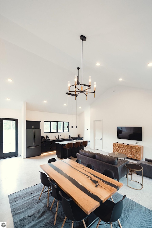 dining room with sink, vaulted ceiling, and an inviting chandelier