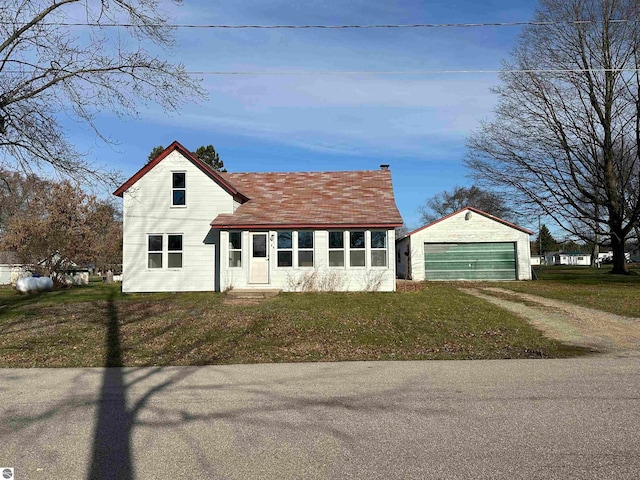 view of front of property with a front yard, an outdoor structure, and a garage