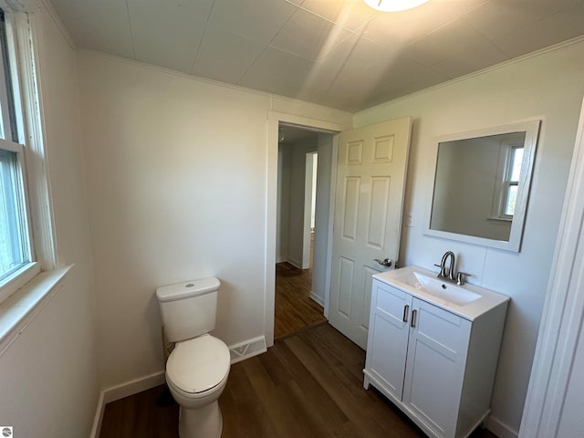 bathroom featuring hardwood / wood-style floors, vanity, ornamental molding, and toilet