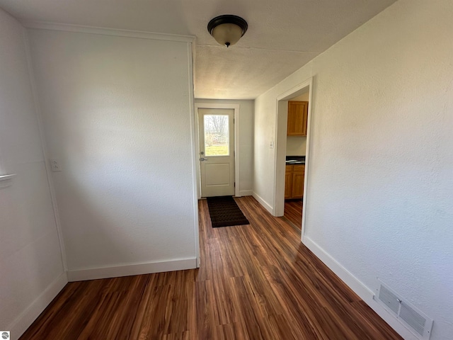 doorway with dark wood-type flooring