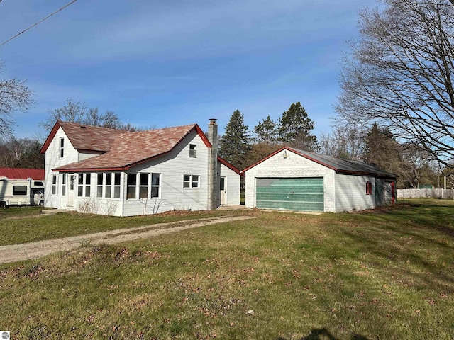 view of property exterior featuring a yard, an outbuilding, and a garage