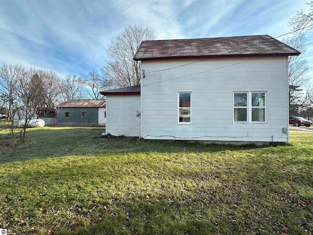 view of side of home with a yard