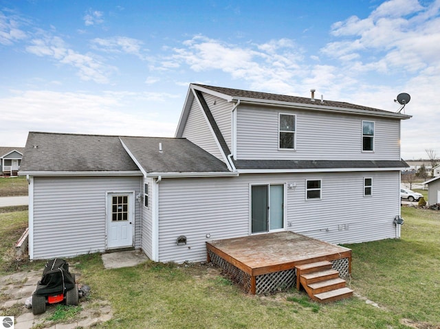 rear view of house featuring a yard and a deck