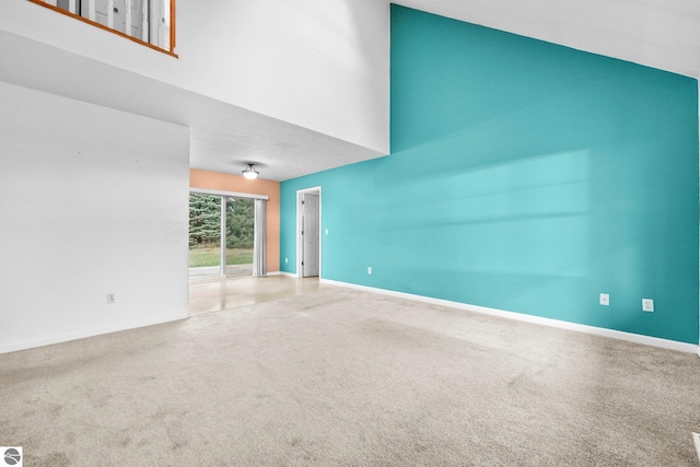 unfurnished living room with carpet floors and a high ceiling