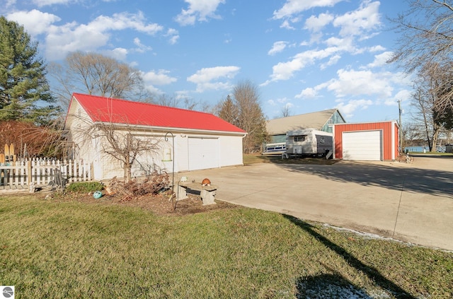 view of side of home featuring a yard, an outbuilding, and a garage