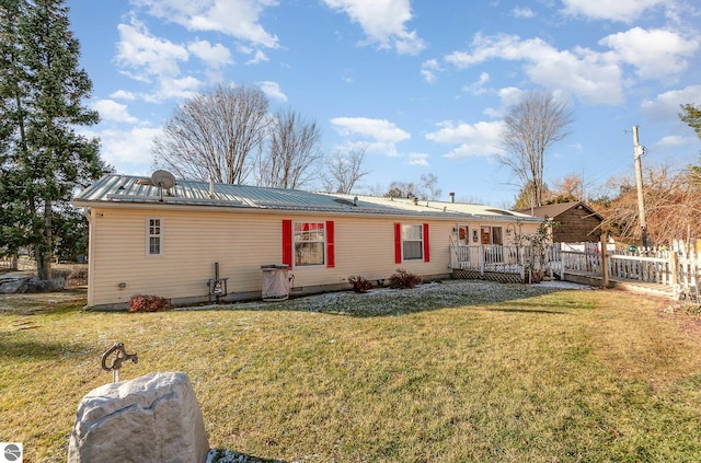 back of house with a lawn and a deck