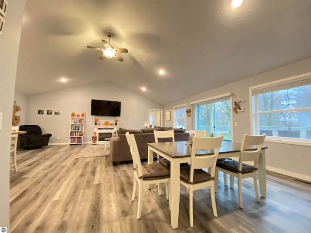 dining space featuring ceiling fan, wood-type flooring, and lofted ceiling