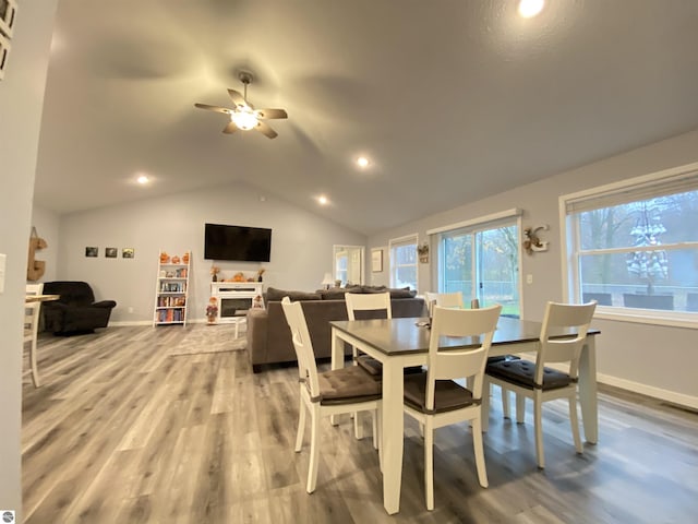 dining space with ceiling fan, wood-type flooring, and lofted ceiling