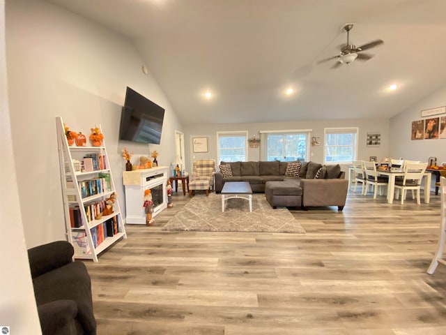 living room featuring light hardwood / wood-style flooring, ceiling fan, and lofted ceiling