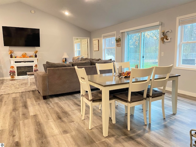 dining space featuring light hardwood / wood-style floors and lofted ceiling