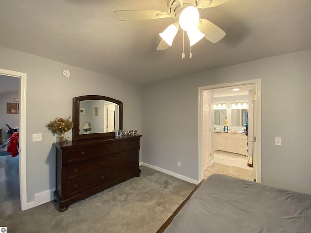 bedroom featuring light colored carpet, ensuite bath, and ceiling fan