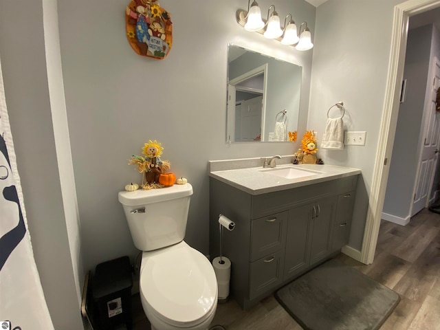 bathroom with toilet, vanity, and hardwood / wood-style flooring