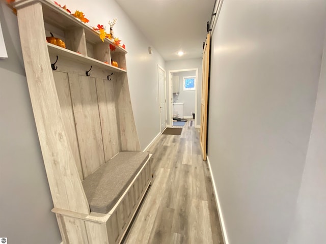 mudroom with light wood-type flooring and a barn door