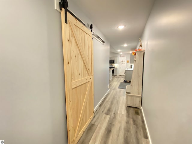 hallway featuring a barn door and hardwood / wood-style flooring