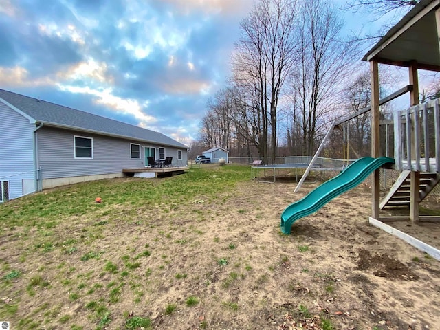 view of yard featuring a playground and a trampoline