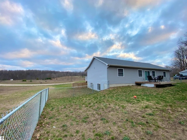 view of property exterior with a lawn and a deck