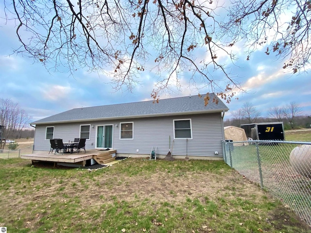 back of house featuring a lawn and a deck