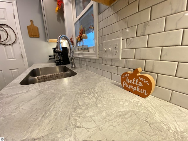 kitchen featuring light stone countertops and sink