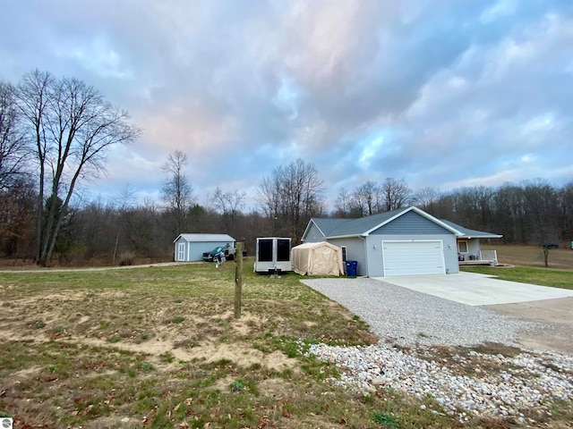 view of front of home with a shed, a front lawn, and a garage