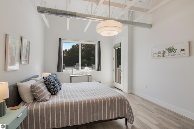 bedroom featuring beam ceiling, high vaulted ceiling, and light hardwood / wood-style flooring