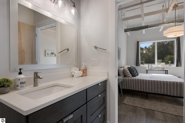 bathroom with hardwood / wood-style floors, vanity, and beam ceiling