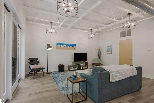 living room with beamed ceiling, wood-type flooring, and a high ceiling