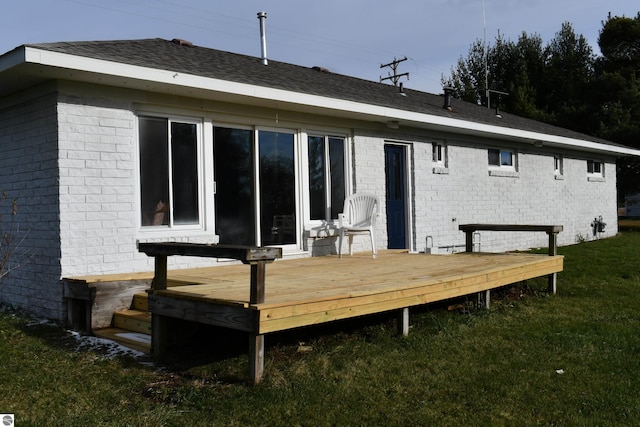 rear view of house featuring a lawn and a deck