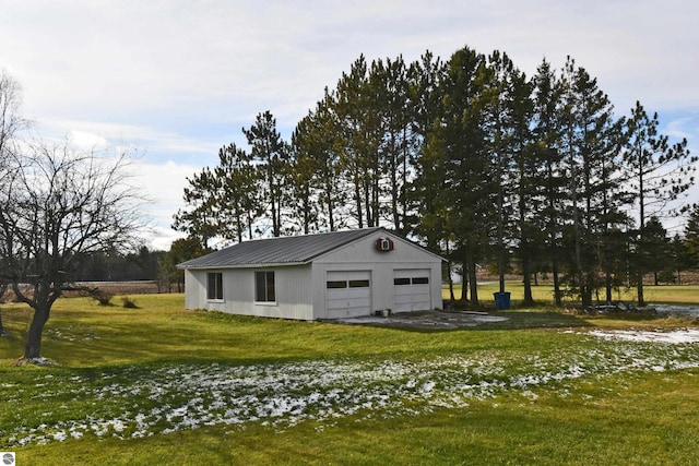 view of side of property featuring a yard, a garage, and an outdoor structure