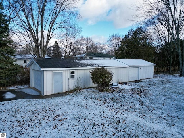 snow covered structure with a garage