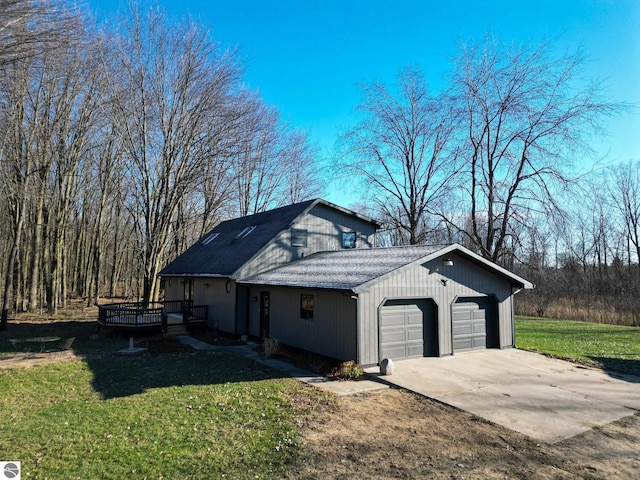 view of side of property featuring a lawn, a wooden deck, and a garage