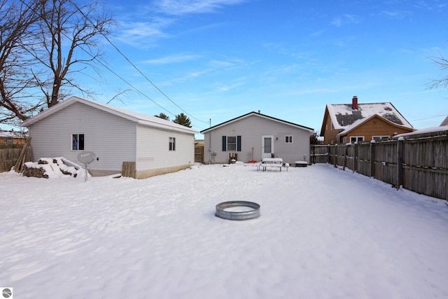 snow covered house with an outdoor fire pit