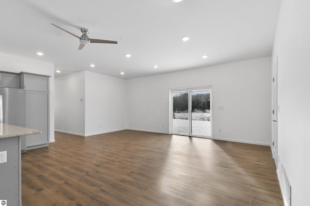 unfurnished living room with ceiling fan and dark wood-type flooring