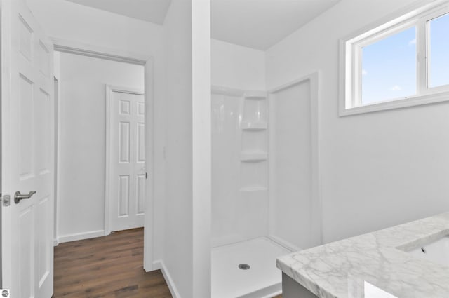 bathroom featuring hardwood / wood-style floors, vanity, and a shower